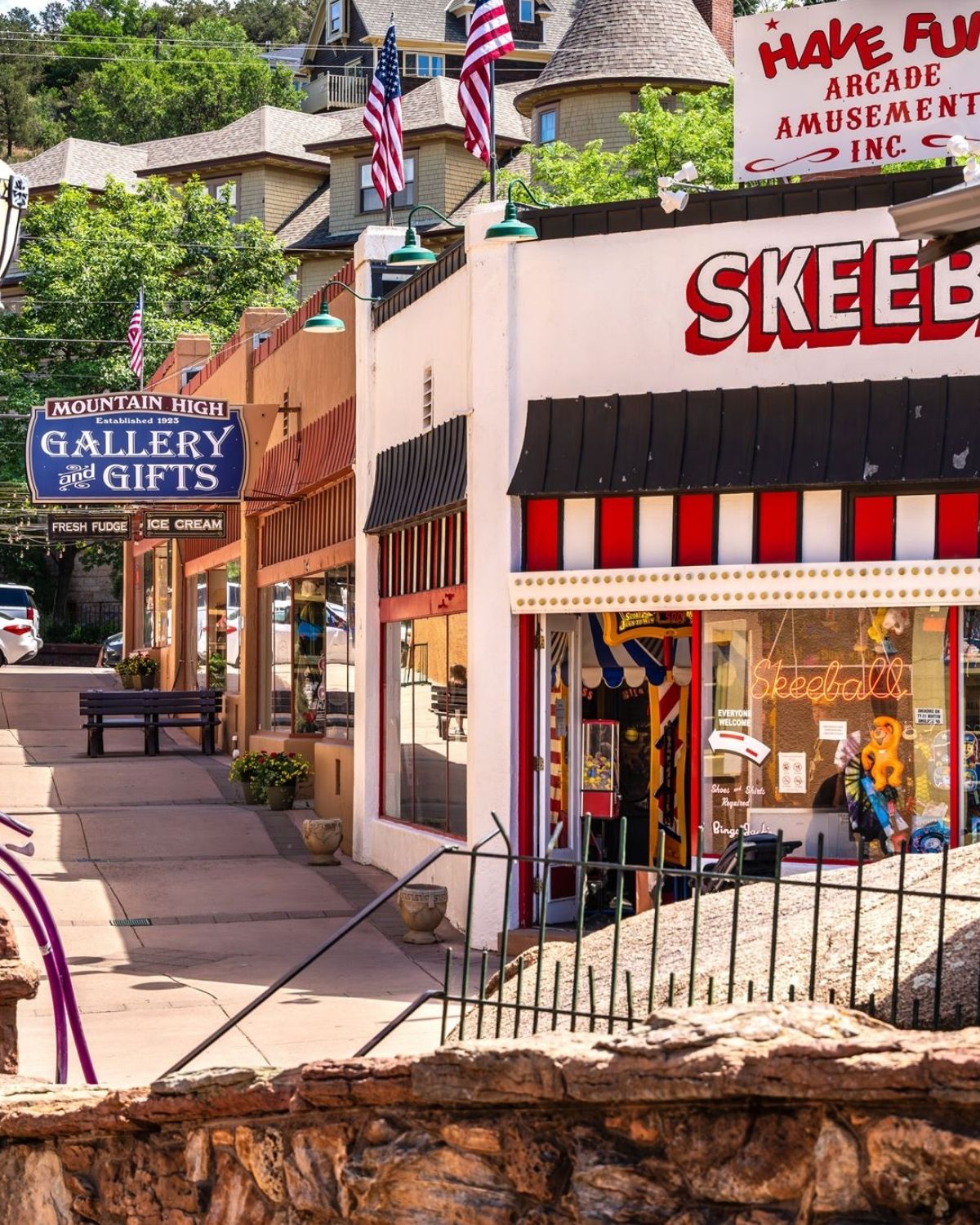 Shopfronts along Manitou Avenue, an arcade and a gallery under striped awnings