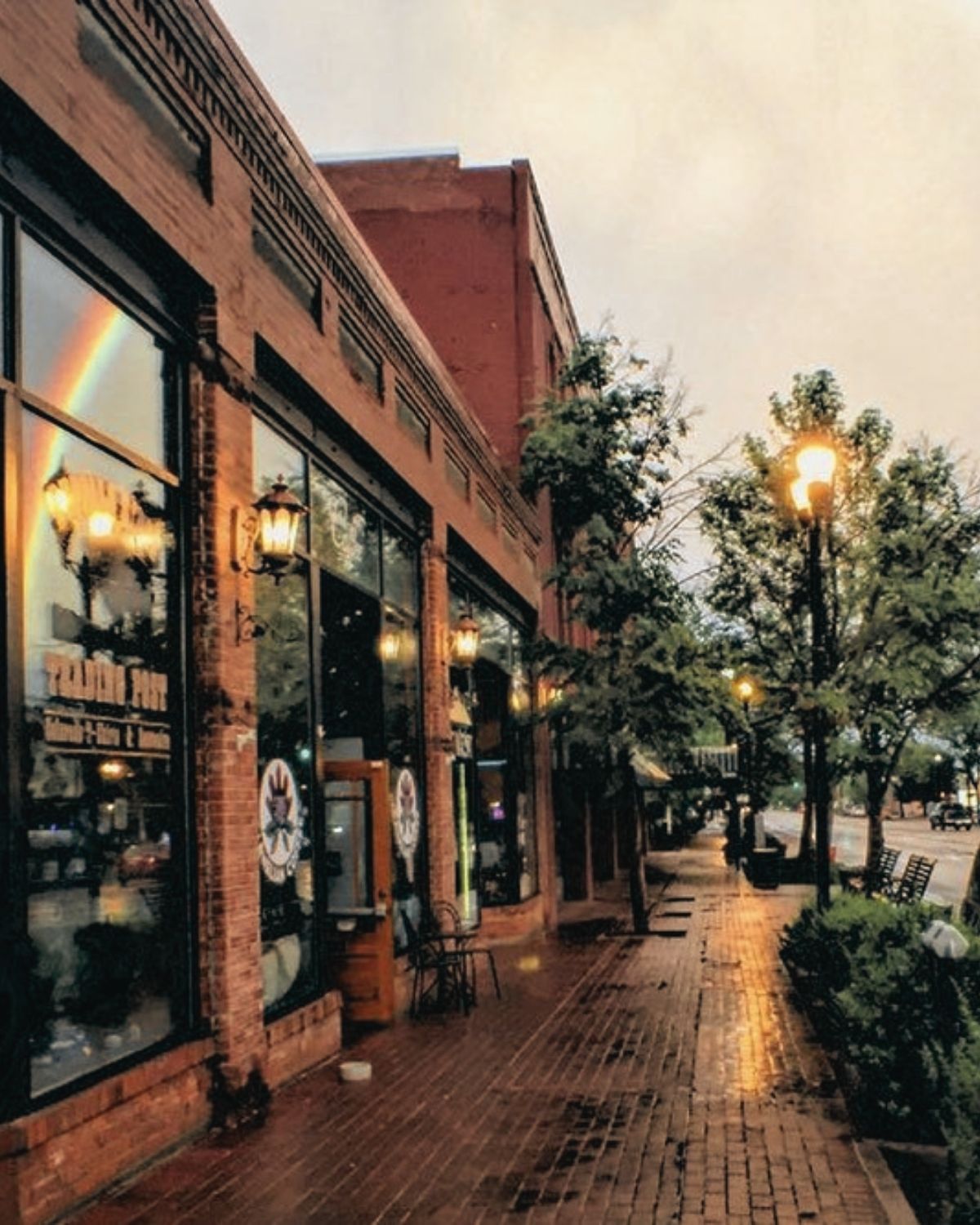 Brick storefronts and lit street lamps along Colorado Avenue in Old Colorado City at dusk
