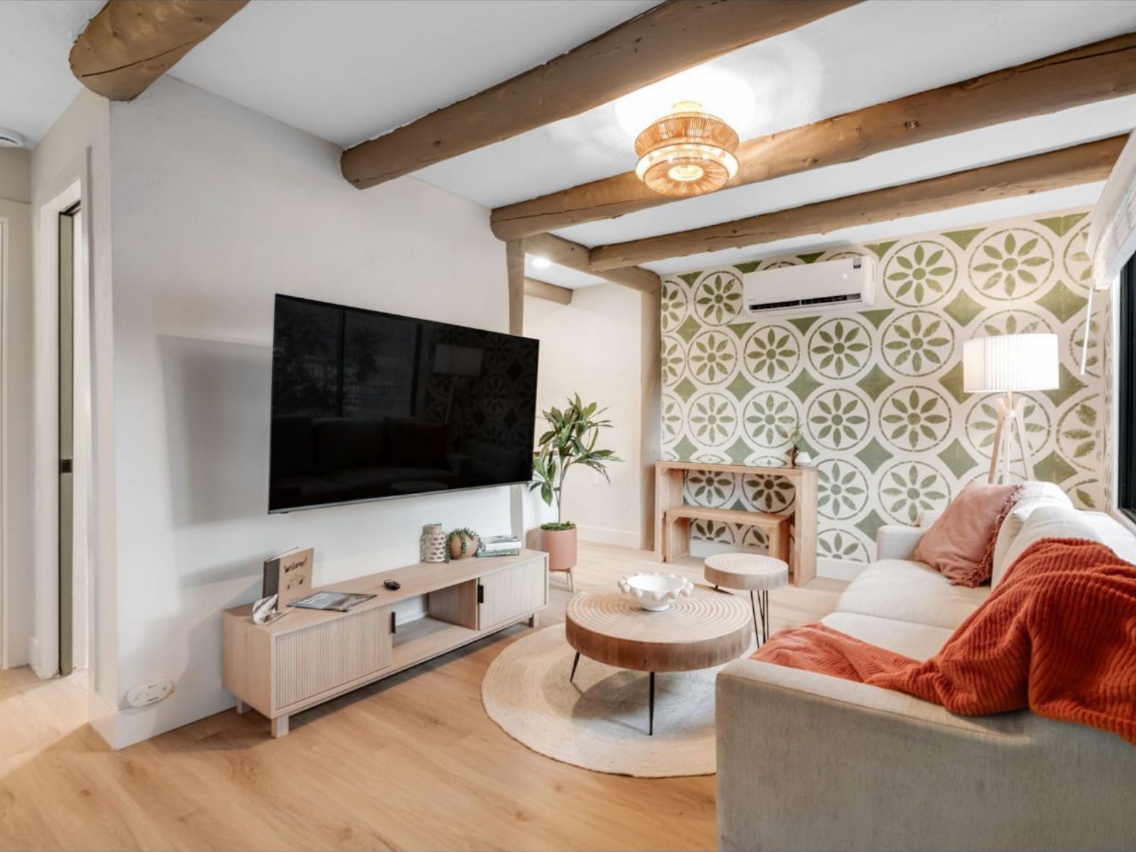 One bedroom casita living room with a sofa, wall-mounted TV and green tilework wall